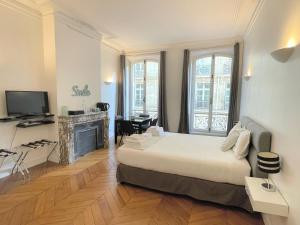 1 dormitorio con 1 cama grande y chimenea en Paris Square, en París