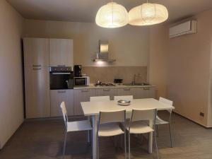 una cucina con tavolo bianco e sedie bianche di Appartamenti Area123 a Diano Marina