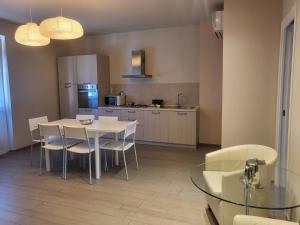una cucina con tavolo e sedie e una sala da pranzo di Appartamenti Area123 a Diano Marina