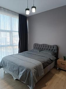 um quarto com uma cama e uma grande janela em Nur Sena's House em Istambul