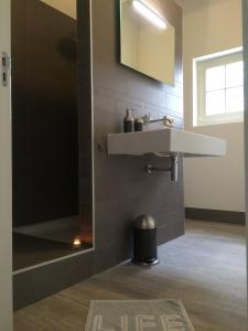 a bathroom with a sink and a mirror at Kerkplein Vakanties in Vrouwenpolder