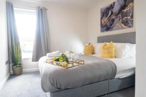 a bedroom with a bed with a table on it at OLD LISTING Cardiff Bay, Modern Chic 2BR, Free Parking in Cardiff