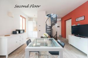 een woonkamer met een witte tafel en een trap bij Heart Centre Milan Navigli 3 Levels Apartment in Milaan