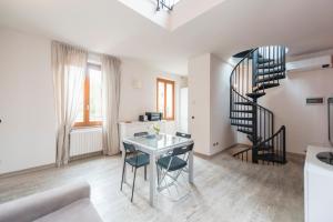 ein Wohnzimmer mit einer Wendeltreppe und einem Tisch in der Unterkunft Heart Centre Milan Navigli 3 Levels Apartment in Mailand
