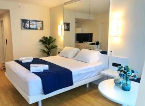 een slaapkamer met een groot wit bed en een spiegel bij Orbi City in Batoemi