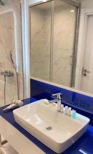 a bathroom with a white sink and a shower at Orbi City in Batumi