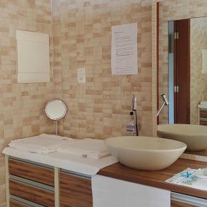 a bathroom with two sinks and a mirror at Pousada Familiar Morada Lua Nova in Florianópolis