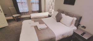 a bedroom with a large bed with white sheets and pillows at The Glebe Hotel in Liverpool