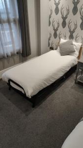 a bed in the corner of a room at The Glebe Hotel in Liverpool