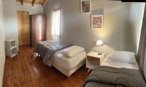 um pequeno quarto com duas camas e um candeeiro em Hermosa y confortable casita en Bariloche em San Carlos de Bariloche