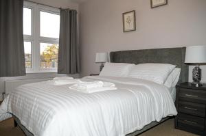 1 dormitorio con 1 cama blanca y ventana en Luxury 5 Star London Apartment - Parking, Garden, nr Greater London Metro Stations en Forest Hill
