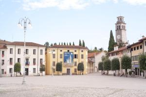a city street with buildings and a clock tower at Albergo Montenegro in Maniago