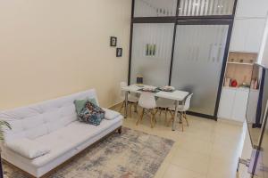 - un salon avec un canapé blanc et une table dans l'établissement Click Apê Cataratas Luxo, à Foz do Iguaçu