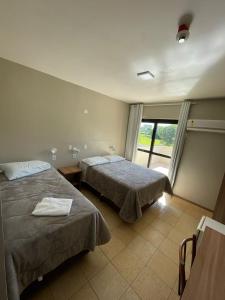 a hotel room with two beds and a window at Executivo Park Hotel in São Borja