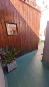 uma cerca de madeira com um vaso de plantas num pátio em Terracita /mini casa centrica em Mendoza
