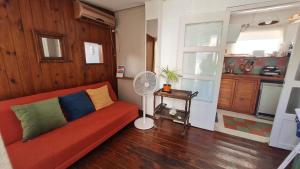 uma sala de estar com um sofá vermelho e uma ventoinha em Terracita /mini casa centrica em Mendoza