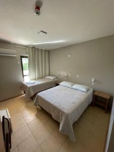 een slaapkamer met 2 bedden en een raam bij Executivo Park Hotel in São Borja