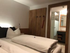 a bedroom with a white bed and a bathroom at Gasthof Bergblick in Berwang