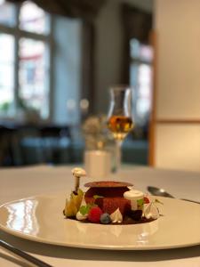 瓦爾迪爾恩的住宿－Hotel & Restaurant Zum Riesen，桌上的一小块食物,加上一杯葡萄酒
