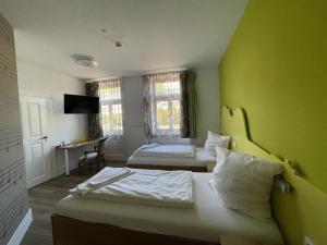 una habitación de hotel con 2 camas y una pared verde en HOTEL Bahnhof Balingen en Balingen