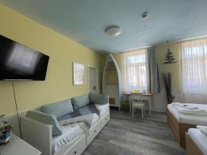 a living room with a couch and a flat screen tv at HOTEL Bahnhof Balingen in Balingen