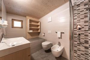 a bathroom with a white sink and a toilet at Le Table E in San Vigilio Di Marebbe