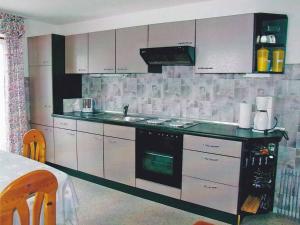 a kitchen with white cabinets and a stove top oven at Ferienwohnung Heitzinger in Bad Birnbach