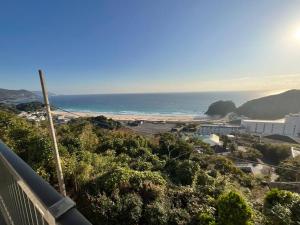 a view of a beach and the ocean from a balcony at Sirahama Beach House in Shimoda