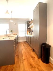 a large kitchen with a wooden floor and a counter at A beautiful and stylish 2 bed flat close to beach in Bournemouth