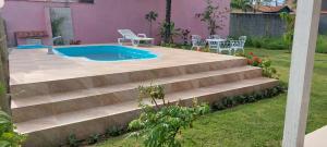 um conjunto de escadas que levam a uma piscina em Casa de Praia - LONG BEACH - Cabo Frio - Unamar em Angelim