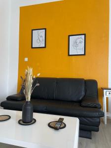 a black couch in a living room with a table at City Pension Bremerhaven in Bremerhaven