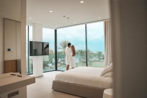 a woman standing in a bedroom looking out the window at Mythical Villas Zeus and Venus in Protaras +52 photos