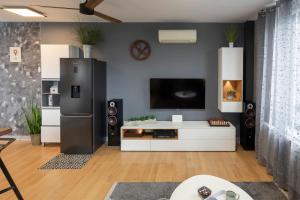 a living room with a black refrigerator and a tv at New Gallery Best West Apartment 310 in Zagreb