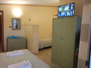 ニコーテラ・マリーナにあるAgriturismo Cally Callyの緑のキャビネット(上部にテレビ付)が備わるバスルームが備わります。