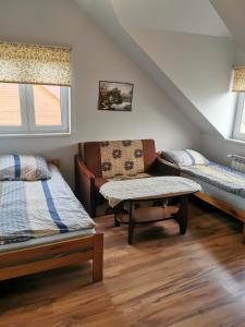 Habitación con 2 camas, sofá y mesa. en Pokoje Gościnne Agnes, en Sanok