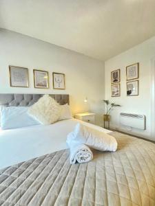 a bedroom with a large bed with white sheets at Four Oaks in Bournemouth