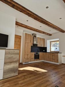 a kitchen with wooden cabinets and a flat screen tv at Apart Schlatter in Prutz