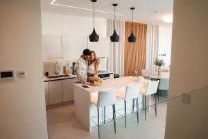 a man and a woman standing in a kitchen at Mythical Villas Zeus and Venus in Protaras