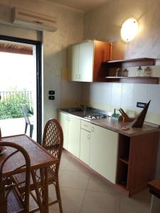 une cuisine avec des placards blancs et une table avec des chaises dans l'établissement Agriturismo Cally Cally, à Nicotera Marina
