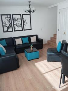 sala de estar con sofá negro y muebles azules en Hermosa casa compartida, estilo minimalista, en Quito