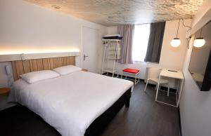 - une chambre avec un grand lit blanc et un bureau dans l'établissement ibis Auxerre Centre, à Auxerre