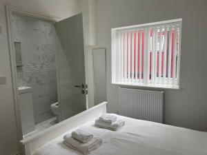 a bathroom with a bed with two towels on it at Beautiful 6 bedroom home close to city centre with free parking in Liverpool