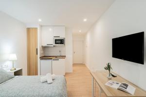 Cet appartement comprend une chambre avec un lit et une table ainsi qu'une cuisine. dans l'établissement Room Plaza España, à Madrid