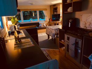 a kitchen and living room with a stove top oven at Shell Beach Holiday Home Mersea Coopers Beach in East Mersea