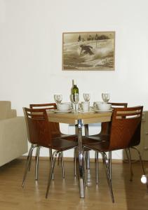 a dining room table with chairs and a bottle of wine at Apartmán 302 Oščadnica in Oščadnica