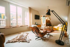 ein Wohnzimmer mit einem Stuhl und einer Lampe in der Unterkunft Domaine Bohème I art de vivre in Guebwiller
