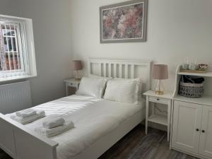 a white bed with two towels on top of it at Beautiful 6 bedroom home close to city centre with free parking in Liverpool