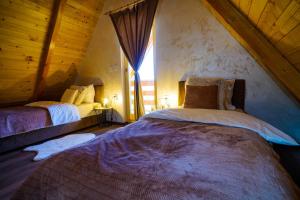 a bedroom with two beds in a attic at Sunset Lux Cottage Ravna Planina Pale - Jahorina in Pale