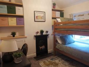 a bedroom with a bunk bed and a fireplace at Prime location for Snowdon, Family and Dog friendly! in Llanberis