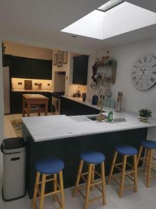 uma cozinha com um balcão e três bancos de bar azuis em Prime location for Snowdon, Family and Dog friendly! em Llanberis